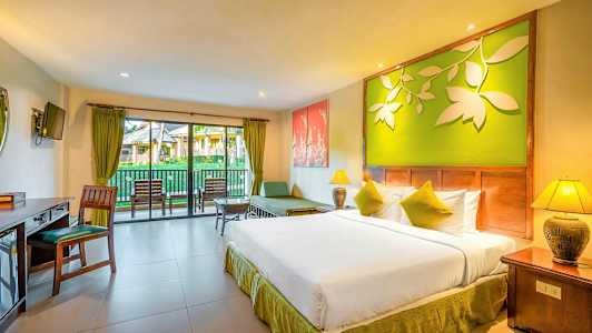 Hotellrum med dubbelsäng, sittgrupp och balkong med utsikt över trädgård. (AI-genererad text)