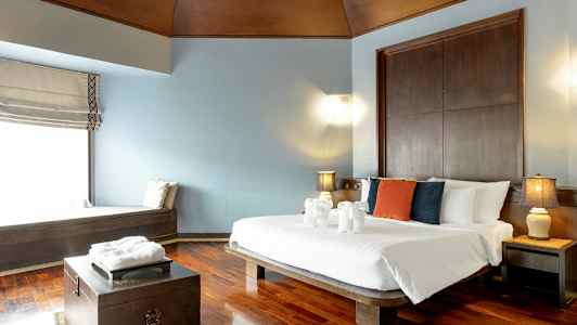 Ett hotellrum med en dubbelsäng, kuddar i olika färger på sängen, och dekorationer av handdukar formade som djur. (AI-genererad text)