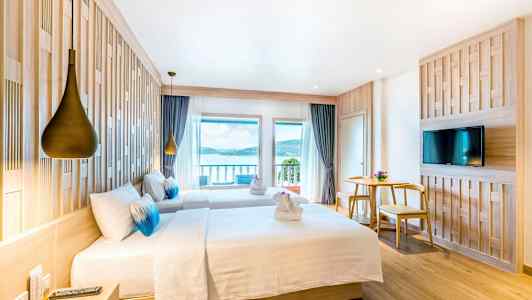 Hotellrum med två sängar, utsikt över havet och modern inredning. (AI-genererad text)