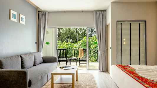 Modernt möblerat hotellrum med balkong och grön utsikt. (AI-genererad text)