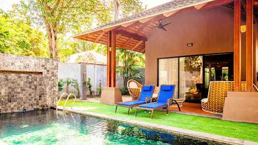 En villa med swimmingpool och solstolar på gräsmattan. (AI-genererad text)