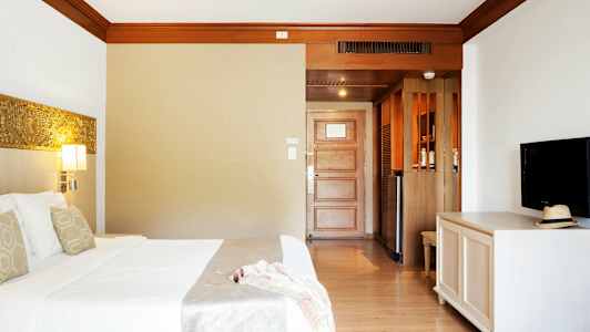 Hotellrum med säng, TV och dörr. (AI-genererad text)