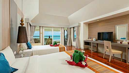 Ett hotellrum med två sängar, en balkong med havsutsikt och en skrivbordshörna. (AI-genererad text)