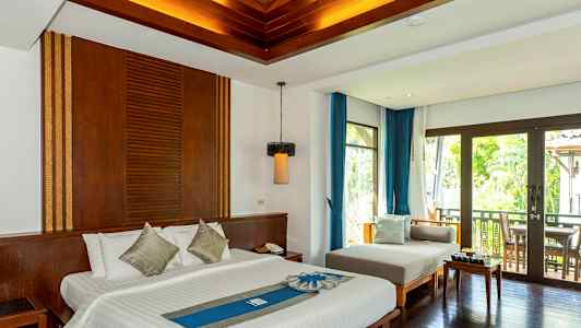 Ett hotellrum med en dubbelsäng, soffgrupp och balkong med utsikt. (AI-genererad text)