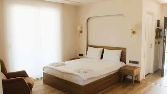 Ett hotellrum med en dubbelsäng, en fåtölj och en nattduksbord. (AI-genererad text)