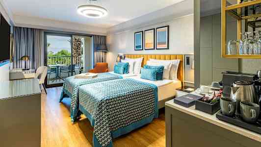 Hotellrum med två enkelsängar, balkong och kaffestation. (AI-genererad text)