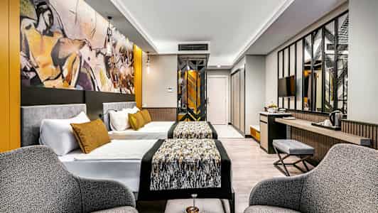 Modernt hotellrum med två sängar, sittgrupp och konst på väggen. (AI-genererad text)