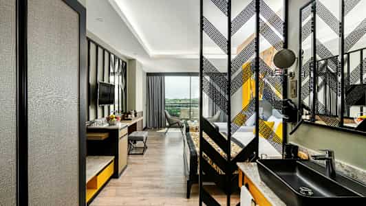 Bild av ett modernt hotellrum med skrivbord, stol och TV samt en separat sovdel. (AI-genererad text)