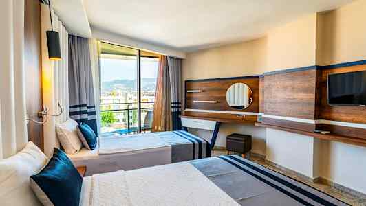 Hotellrum med två sängar och utsikt genom glasdörrar mot berg. (AI-genererad text)