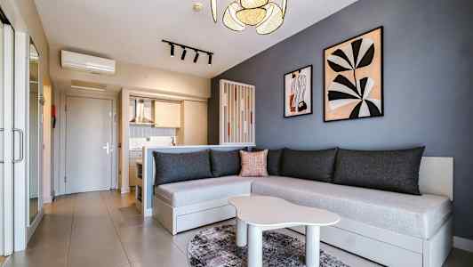 Modernt inrett rum med kök, soffa och väggdekorationer. (AI-genererad text)