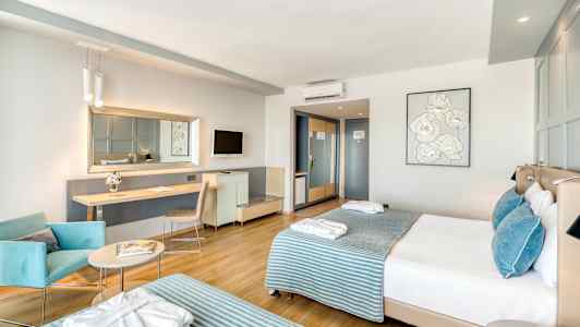 Modernt hotellrum med två sängar, sittplats och arbetsbord. (AI-genererad text)