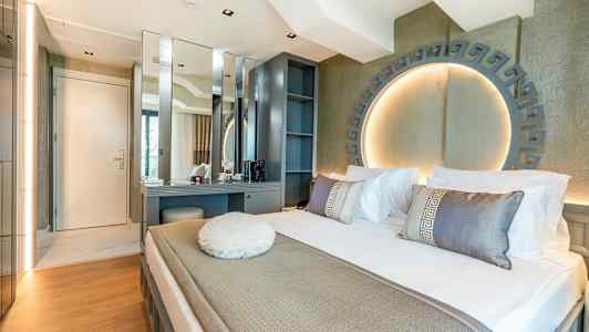 Modernt hotellrum med säng, skrivbord och dekorativ belysning. (AI-genererad text)