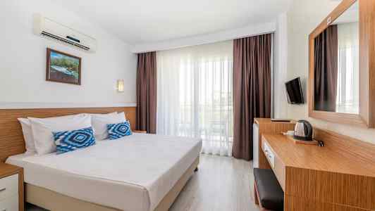 Ett hotellrum med en dubbelsäng, skrivbord och balkong. (AI-genererad text)