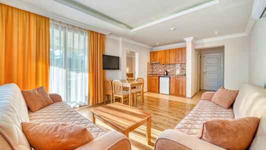 Ett vardagsrum med två soffor, ett soffbord, en matgrupp och ett öppet kök. (AI-genererad text)