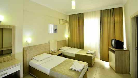 Hotellrum med två enkelsängar, skrivbord och tv. (AI-genererad text)