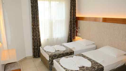 En hotellrum med två enkelsängar och dekorerade sängkläder. (AI-genererad text)