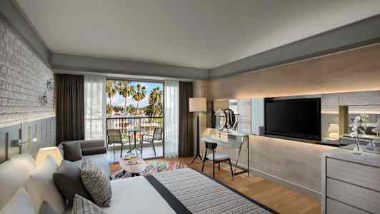 Modernt hotellrum med balkong och utsikt mot palmer. (AI-genererad text)