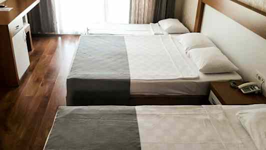 Hotellrum med två sängar och ett skrivbord. (AI-genererad text)