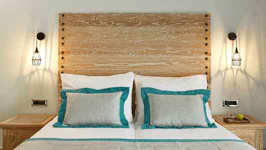 En säng med trähuvudgavel och två sidobord. (AI-genererad text)