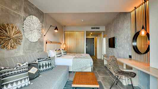 Ett hotellrum med två sängar, en soffa och inredningsdetaljer. (AI-genererad text)