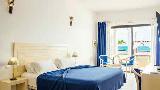 Hotellrum med säng, möbler och havsutsikt. (AI-genererad text)