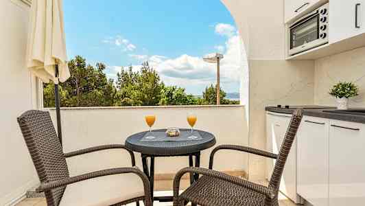 Balkong med bord, stolar och utsikt. (AI-genererad text)