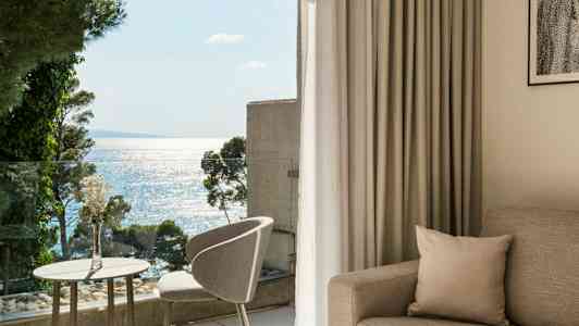 Ljus och modern hotellrum med havsutsikt från balkongen. (AI-genererad text)