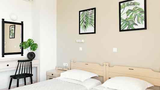 Hotellrum med två enkelsängar, ett skrivbord och väggdekorationer med botaniska motiv. (AI-genererad text)