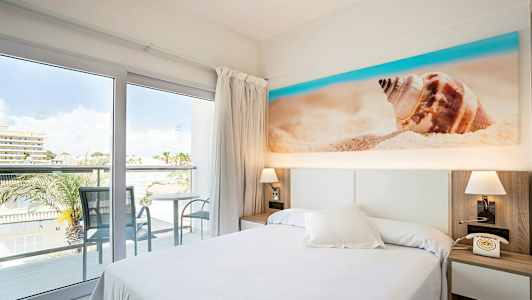 Hotellrum med balkong och utsikt, säng och dekoration av strandmotiv. (AI-genererad text)