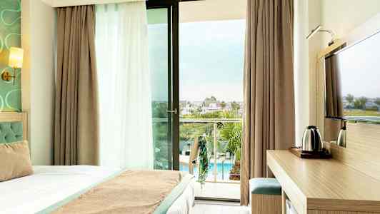 Hotellrum med balkong som har utsikt över poolområdet. (AI-genererad text)