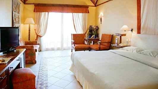 Ett hotellrum med säng, sittgrupp och en TV. (AI-genererad text)