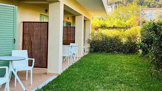 Exteriör av en byggnad med gräsmatta och sittplatser utanför. (AI-genererad text)