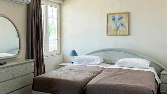 Hotellrum med två enkelsängar, ett skrivbord och en spegel. (AI-genererad text)