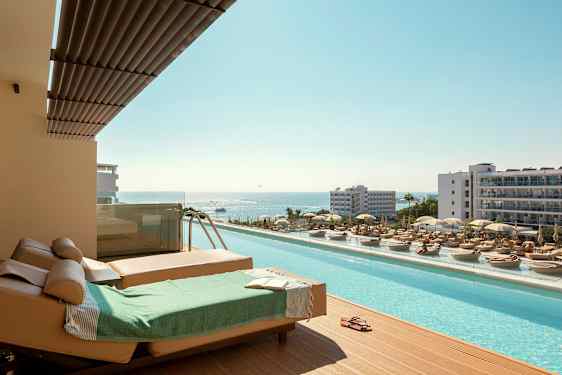 Solstolar och pool med utsikt över havet i en semesterort. (AI-genererad text)