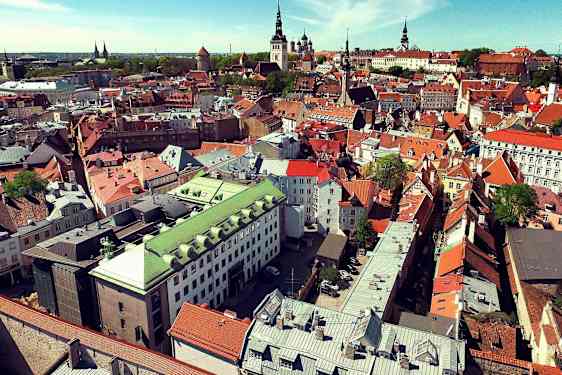 Flygvy över en stad med äldre byggnader i olika färger. (AI-genererad text)