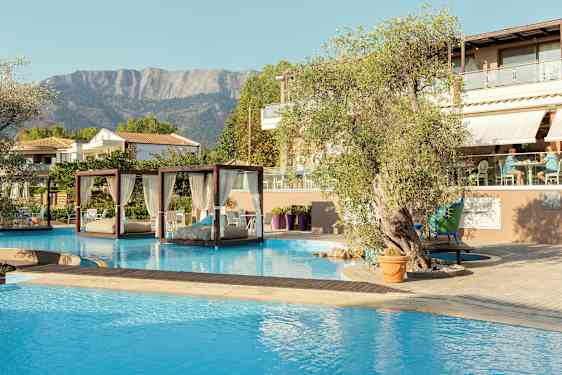 En pool med balinesiska dagbäddar och ett hotell med sittområde i bakgrunden. (AI-genererad text)