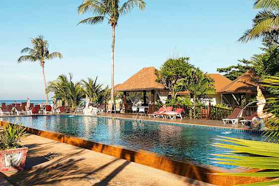 Bild av en poolområde med palmer, solstolar och bungalow-liknande byggnader i bakgrunden. (AI-genererad text)