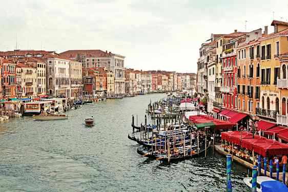 En kanal med gondoler och färgglada byggnader på båda sidor i Venedig. (AI-genererad text)