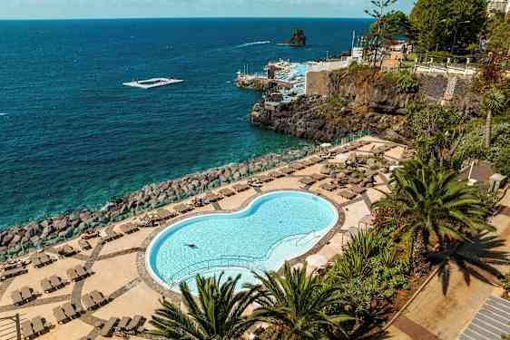 Sluten pool med vilstolar och utsikt över havet. (AI-genererad text)