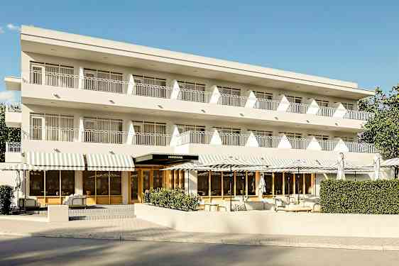 Tre vånings byggnad med balkonger och entré med vita markiser. (AI-genererad text)