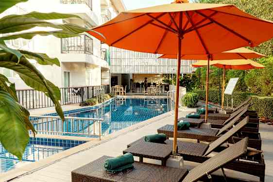 Solstolar och parasoller vid en pool på ett hotell. (AI-genererad text)