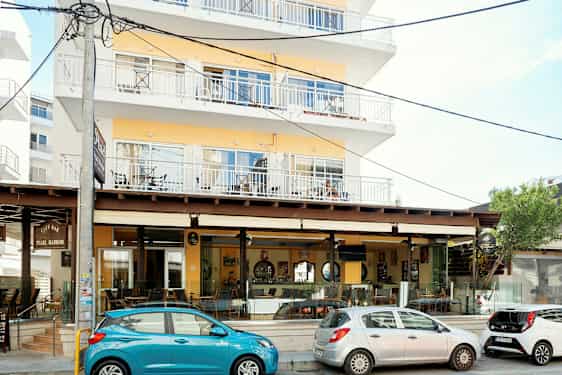 Flerfamiljshus med café längs gatan. (AI-genererad text)