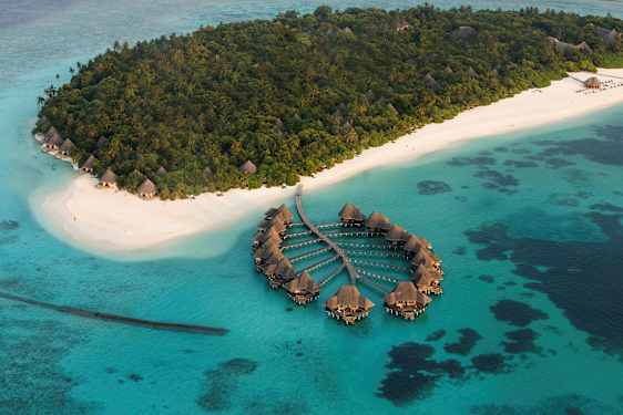 Flygfoto av tropisk ö med vita sandstränder och övervattensvillor. (AI-genererad text)