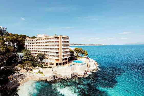 Hotell vid kust med pool och utsikt över havet. (AI-genererad text)