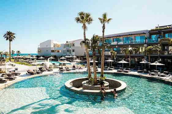 En utomhuspool med omgivande solstolar och palmer vid ett modernt hotell. (AI-genererad text)