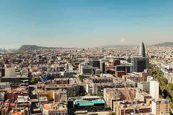 Vy över en stad med flera byggnader och en unik hög byggnad synlig. (AI-genererad text)