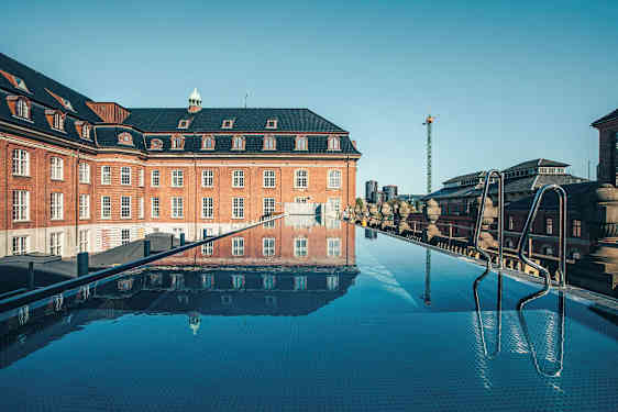 En takpool med utsikt över en gammal byggnad i tegel. (AI-genererad text)