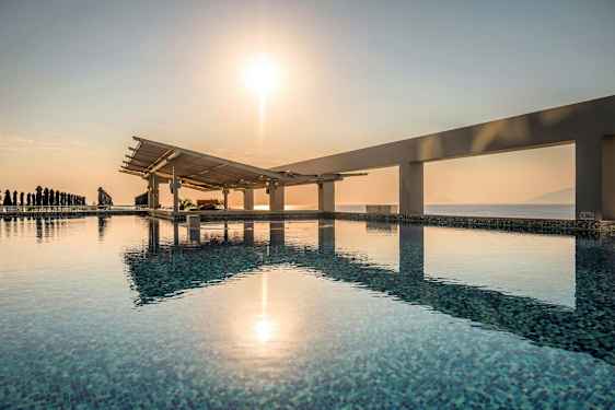 En pool med utsikt över havet och en soluppgång. (AI-genererad text)