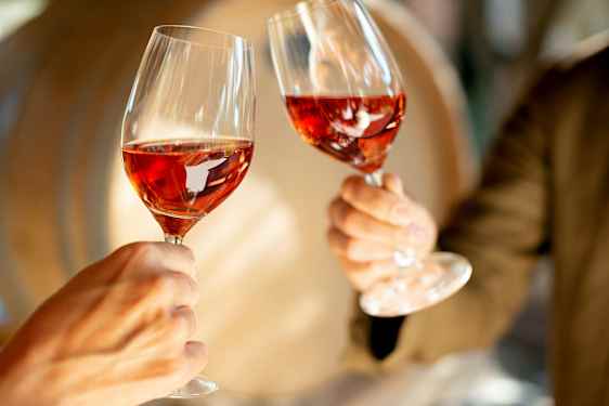 Två glas med rosévin hålls upp. (AI-genererad text)