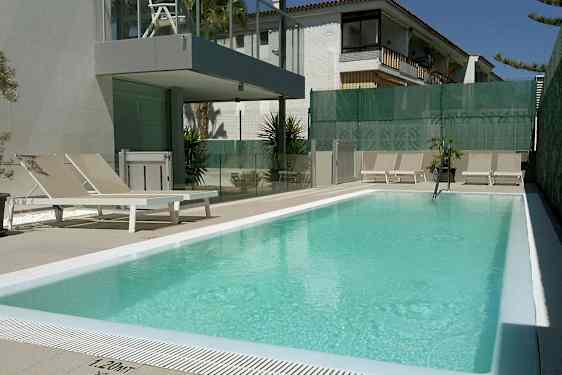 Uteplats med pool och solstolar. (AI-genererad text)